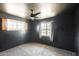 Bedroom with dark gray walls, two windows, ceiling fan, and carpeted floor at 3001 N 21St Ave, Phoenix, AZ 85015