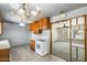 Bright kitchen with wooden cabinets, white appliances, chandelier, and view to the living room at 3001 N 21St Ave, Phoenix, AZ 85015