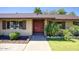 Inviting home facade featuring a brick exterior, red double doors, and mature landscaping at 3009 W Christy Dr, Phoenix, AZ 85029