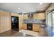 Bright kitchen features wood cabinetry, stainless vent hood, black appliances, and gray countertops at 3009 W Christy Dr, Phoenix, AZ 85029