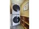 Efficient laundry room with stacked washer and dryer unit, accompanied by convenient storage shelves at 3009 W Christy Dr, Phoenix, AZ 85029