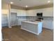 Modern kitchen boasts white cabinets, center island, stainless steel appliances, and ample counter space at 31878 N Bandit Rd, San Tan Valley, AZ 85143