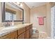 Bathroom featuring granite counters, double sinks, a toilet, and a large framed mirror at 4556 W Cholla St, Glendale, AZ 85304