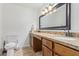 Bathroom featuring granite counters, double sinks, a toilet, and a large framed mirror at 4556 W Cholla St, Glendale, AZ 85304
