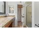 This bathroom features a single sink with granite counters, a mirror, and a walk-in shower at 4556 W Cholla St, Glendale, AZ 85304
