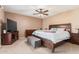 This main bedroom features a ceiling fan, carpet, TV, and a dark wood sleigh bed at 4556 W Cholla St, Glendale, AZ 85304
