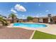 Sparkling blue pool surrounded by rock landscaping, complemented by turf and a backyard view at 4556 W Cholla St, Glendale, AZ 85304