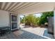 Covered patio area with access door, featuring pavers and views of the yard with mature plants at 4629 N 9Th St, Phoenix, AZ 85014