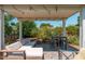 Relaxing covered patio area featuring a comfortable lounge sofa, table with chairs, and mature landscaping at 4629 N 9Th St, Phoenix, AZ 85014