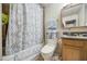 This bathroom showcases a shower and tub combo with decorative curtain, toilet, vanity, and decor at 5119 N 87Th St, Scottsdale, AZ 85250