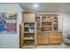 Charming kitchen storage with wood cabinets, pull out drawers, wine rack and decorative glass doors at 5119 N 87Th St, Scottsdale, AZ 85250