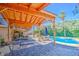 Inviting outdoor living space with a covered patio, poolside seating, and a tranquil view of the refreshing pool at 5119 N 87Th St, Scottsdale, AZ 85250
