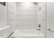 Bathroom tub and shower area with white marble tile and brushed bronze fixtures at 5808 S 12Th Ln, Phoenix, AZ 85041