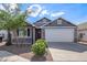 Charming single-story home featuring a red front door, a two-car garage, and desert landscaping at 5808 S 12Th Ln, Phoenix, AZ 85041