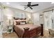 Cozy bedroom featuring a wood-frame bed, ceiling fan, and a sliding barn door to the en-suite bathroom at 5808 S 12Th Ln, Phoenix, AZ 85041