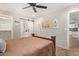 Inviting bedroom showcasing a ceiling fan and an en-suite bathroom with a sliding barn door for privacy at 5808 S 12Th Ln, Phoenix, AZ 85041