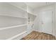 Pantry with white shelves, wood-look flooring, and access to the laundry room at 5808 S 12Th Ln, Phoenix, AZ 85041