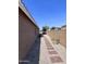 Narrow side yard with a brick path and gravel, enclosed by a block wall at 6049 S Wilson Dr, Chandler, AZ 85249