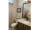 Well-lit bathroom with a decorative shower curtain, framed art, and a marble-topped vanity at 6131 S Bradshaw Way, Chandler, AZ 85249