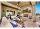 Inviting covered patio with a stone fireplace, outdoor seating, and a mounted TV for entertainment at 6131 S Bradshaw Way, Chandler, AZ 85249