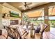 Relaxing covered patio with a stone fireplace, comfortable seating, and a view of the lush backyard and golf course at 6131 S Bradshaw Way, Chandler, AZ 85249