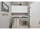 Clean laundry room featuring front-loading washer and dryer, storage cabinets, and gray walls at 6131 S Bradshaw Way, Chandler, AZ 85249