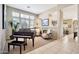 Elegant living room boasts natural light, a baby grand piano, a fireplace, and access to other areas at 6131 S Bradshaw Way, Chandler, AZ 85249