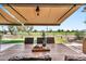 Covered outdoor dining area with views of the manicured backyard, water feature, and golf course beyond at 6131 S Bradshaw Way, Chandler, AZ 85249