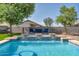 Backyard pool with integrated water features, complemented by a cozy seating area and mature trees at 6321 W Gross Ave, Phoenix, AZ 85043