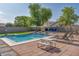Landscaped backyard with a refreshing pool, picnic table, and lounge chairs for relaxation and play at 6321 W Gross Ave, Phoenix, AZ 85043