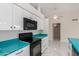Kitchen with white cabinets, black appliances, and turquoise countertops at 643 W Medina Ave, Mesa, AZ 85210