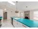 Bright kitchen featuring a skylight, white cabinets, and turquoise countertops at 643 W Medina Ave, Mesa, AZ 85210