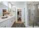 Modern bathroom featuring double sinks, white cabinetry, a glass-enclosed shower, and a walk-in closet at 644 N Vine St, Chandler, AZ 85225
