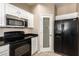 Kitchen featuring black appliances, white cabinets, a pantry, and tile flooring at 7029 S Golfside Ln, Phoenix, AZ 85042