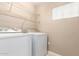 Functional laundry room with washer, dryer, window and wire shelving at 7029 S Golfside Ln, Phoenix, AZ 85042