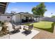 Outdoor living area featuring a covered bar, seating, and a putting green at 7707 E Earll Dr, Scottsdale, AZ 85251