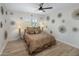 Bedroom with ceiling fan, wood floors, and a large window providing natural light at 7707 E Earll Dr, Scottsdale, AZ 85251