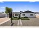 Charming single-story home with white painted brick, grey trim, and a tidy, xeriscaped front yard at 7707 E Earll Dr, Scottsdale, AZ 85251