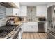 Bright kitchen featuring white cabinetry, stainless steel appliances, farmhouse sink and stylish backsplash at 7707 E Earll Dr, Scottsdale, AZ 85251