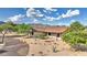 Desert home featuring xeriscaping, mature trees, and views of the nearby mountains against a beautiful blue sky at 833 N 110Th St, Mesa, AZ 85207