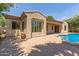 Backyard featuring brick flooring, a covered patio, and a pool with a rock waterfall at 915 W Orchard Ln, Litchfield Park, AZ 85340