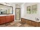 Bright bathroom featuring a soaking tub and a glass-door shower, enhanced by stylish wood cabinets at 915 W Orchard Ln, Litchfield Park, AZ 85340