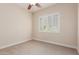 Cozy bedroom with neutral carpet, walls, ceiling fan, and bright shuttered window at 915 W Orchard Ln, Litchfield Park, AZ 85340