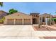 Beautiful desert home with three-car garage, desert landscaping, and lovely arched entryway at 915 W Orchard Ln, Litchfield Park, AZ 85340