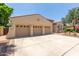 Spacious three-car garage attached to a desert-style home with ample driveway space at 915 W Orchard Ln, Litchfield Park, AZ 85340