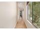 Bright hallway with tile flooring and a large window viewing outdoor foliage at 915 W Orchard Ln, Litchfield Park, AZ 85340
