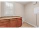 Laundry room featuring built-in cabinets, tile floor, and natural light from a window at 915 W Orchard Ln, Litchfield Park, AZ 85340