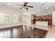 Bright living room area featuring tile and hardwood flooring adjacent to an open kitchen at 915 W Orchard Ln, Litchfield Park, AZ 85340