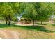 Community park featuring a playground shaded by mature trees and a grassy lawn at 915 W Orchard Ln, Litchfield Park, AZ 85340