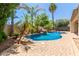 Backyard pool featuring rock waterfall with mature palm trees in the backyard at 915 W Orchard Ln, Litchfield Park, AZ 85340